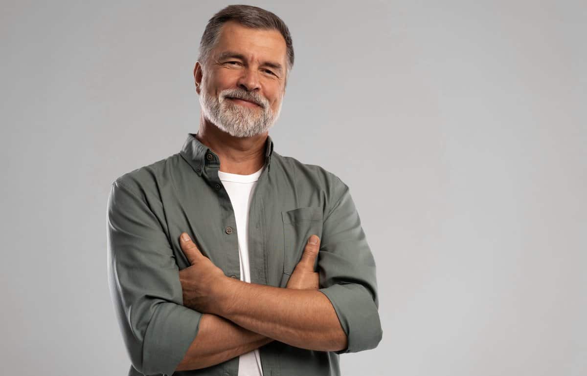 portrait,of,smiling,mature,man,standing,on,white,background.