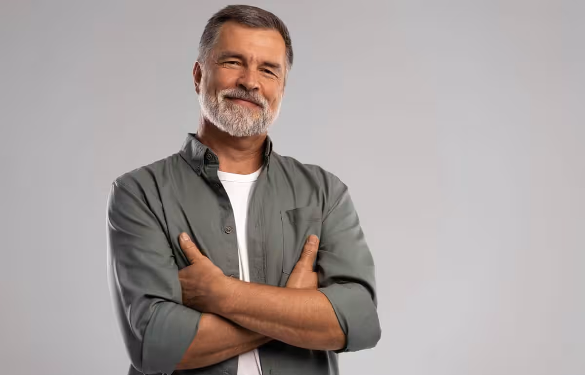 portrait,of,smiling,mature,man,standing,on,white,background.