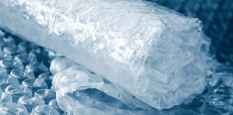 Close-up of crumpled bubble wrap with air filled bubbles, translucent plastic texture against blue background.
