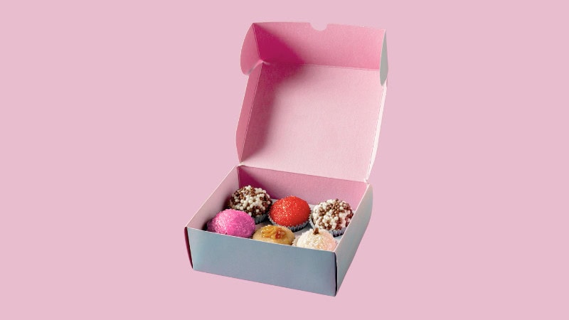 Open small custom dessert box, holding six assorted truffles