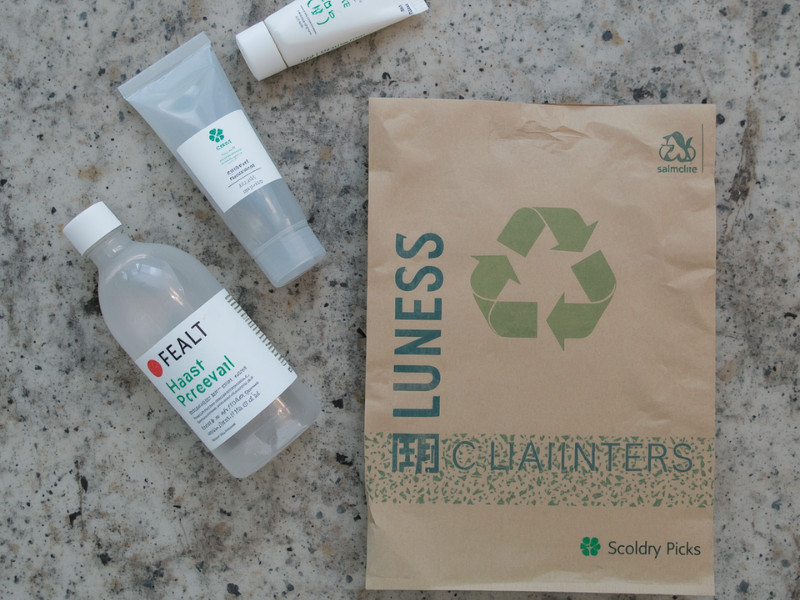 Top‑down view of sustainable skincare packaging including recyclable brown kraft paper bag and reusable containers, reducing plastic waste and environmental impact