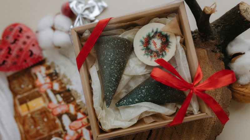several soaps putting in a cardboard box within tissue paper