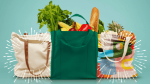 A green shopping bag with vegetables and other groceries