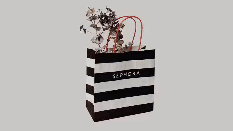 A black and white striped shopping bag with a plant in it