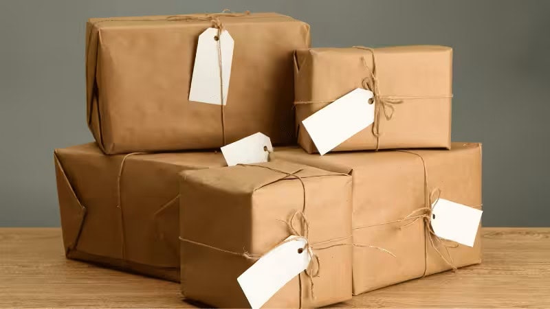 Gestapelte Kraftpapier-Geschenkboxen mit leeren Anhängern und Kordel, perfekt für kreative Geschenkbox-Designideen mit Hülle.