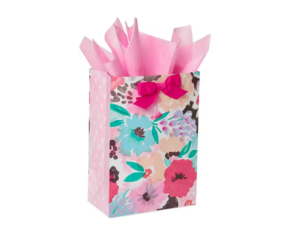 Vibrant floral gift bag with pink tissue paper, perfect for gift giving and following proper gift bag etiquette for any occasion.