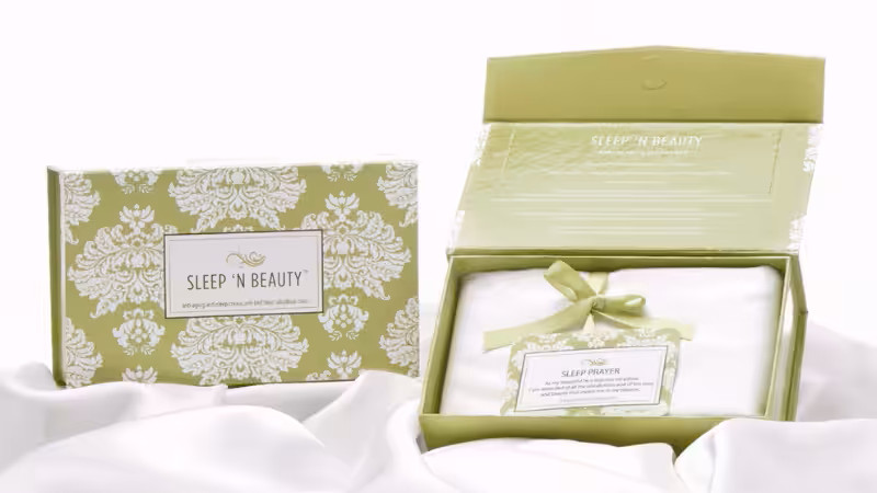 Elegant pink round gift boxes for women, with one open revealing a perfume bottle in gold crinkle paper filler.