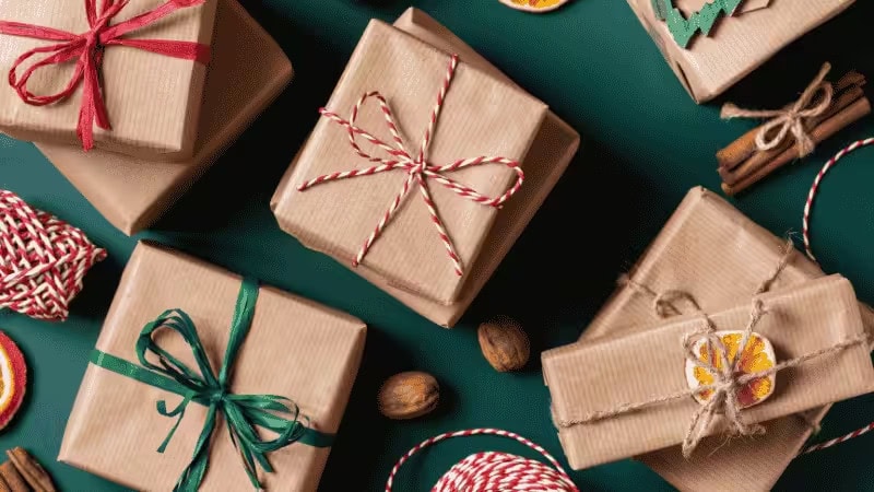 Festlich verpackte Geschenkboxen mit bunten Bändern auf grünem Hintergrund, perfekt als Geschenktütenidee für Kinderweihnachten, Geburtstage und andere Feiertage.
