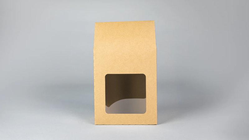 Kraft paper window box packaging with a square clear window, standing on a light gray background.