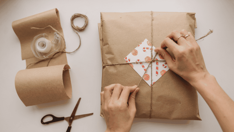 a woman is making a gift packaging