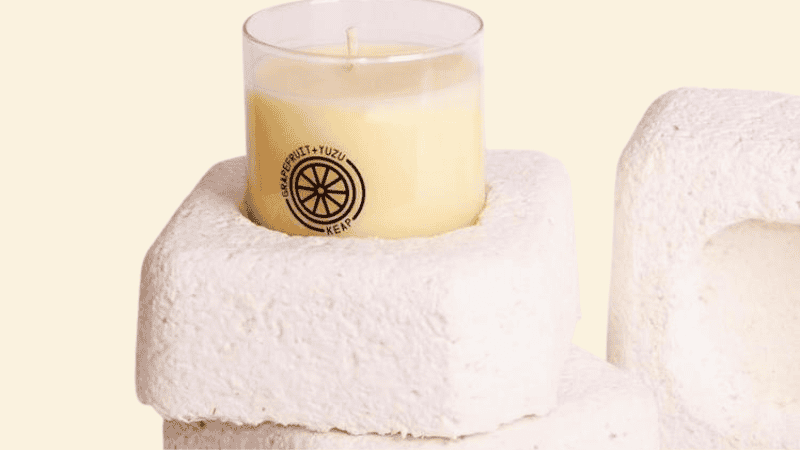 A candle sitting on a mushroom packaging
