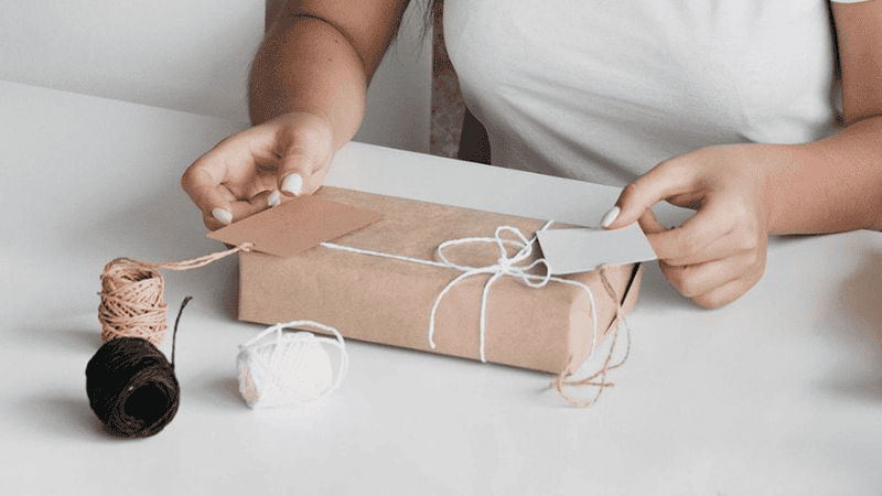 Women wrapping products in Kraft paper packaging