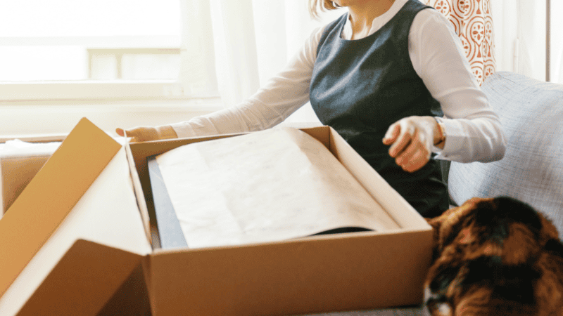 a woman is opening a sustainable box packaging