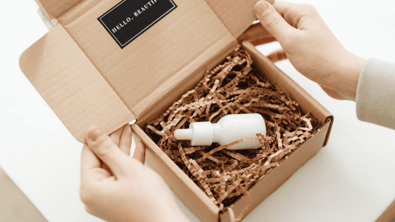 someone is opening a box packaging with paper insert