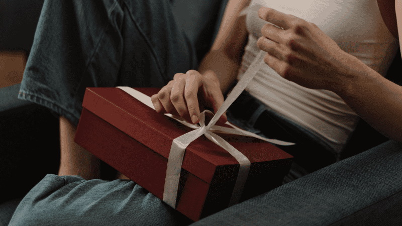 a woman is opening a gift box