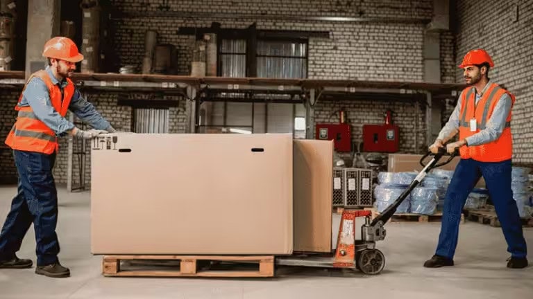 Two men are pushing a large package ready for shipping