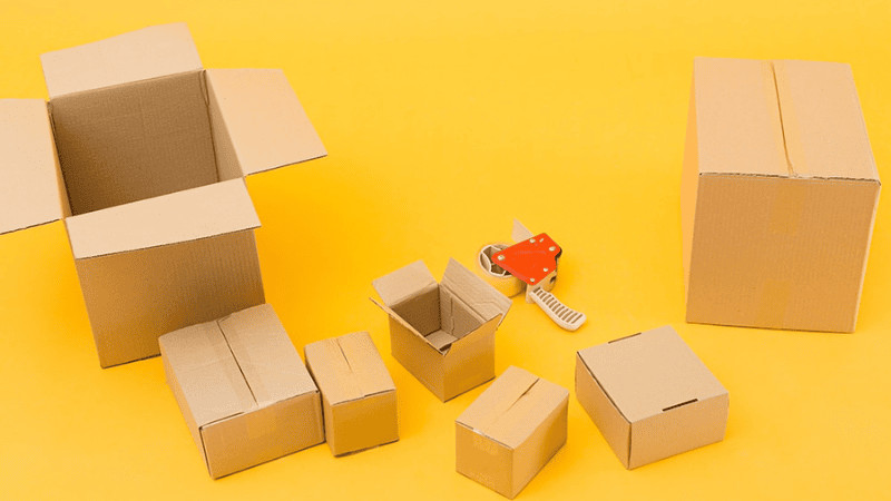 Two men are pushing a large package ready for shipping