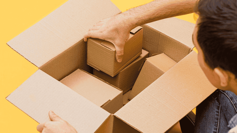 Man consolidating several small packages in one large box